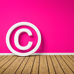 Copyright symbol on wooden floor leaning against pink wall.  Credit:HT-Pix 