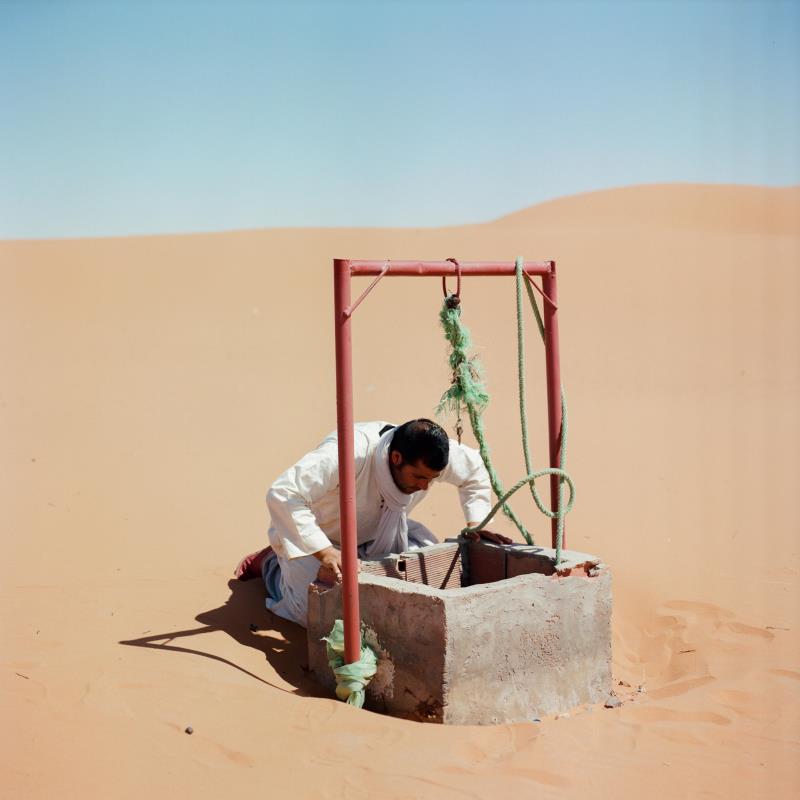 A man checks the water level of a well at Merzouga Oasis, Morocco, on 8 May 2022. Deep wells can deplete the water table, leaving farmers who have no access to them without a supply.